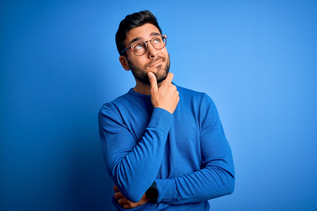 man thinking in front of a blue background