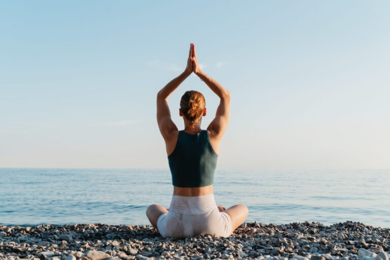 woman on the shore practicing yoga