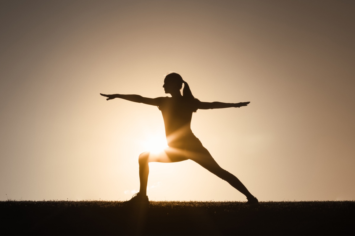 Woman practicing yoga at the sunset