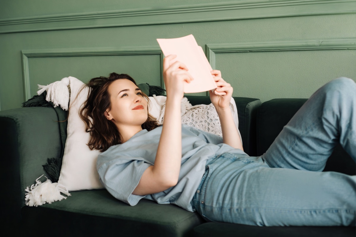 woman reading a book on the couch