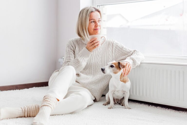 mujer de mediana edad tomando café con su perro
