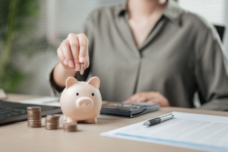 woman putting coins in a piggy bank
