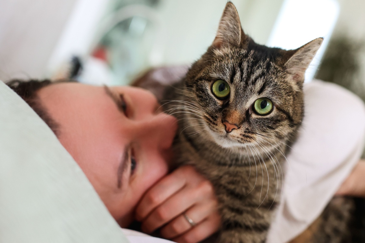 mujer en la cama con un gato