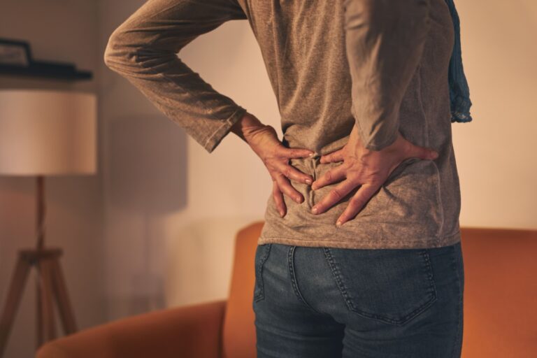 woman holding her back with her hands