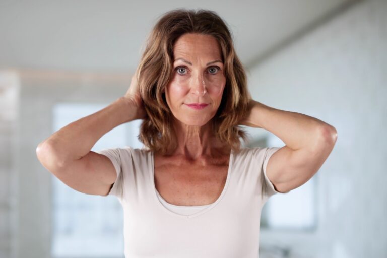mujer de mediana edad con las manos en la nuca