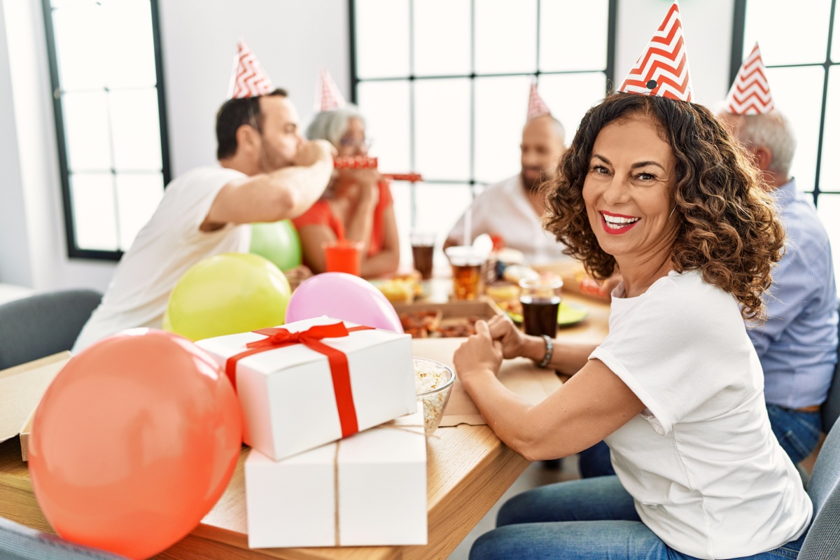 mujer de mediana edad en una mesa celebrando un cumpleaños