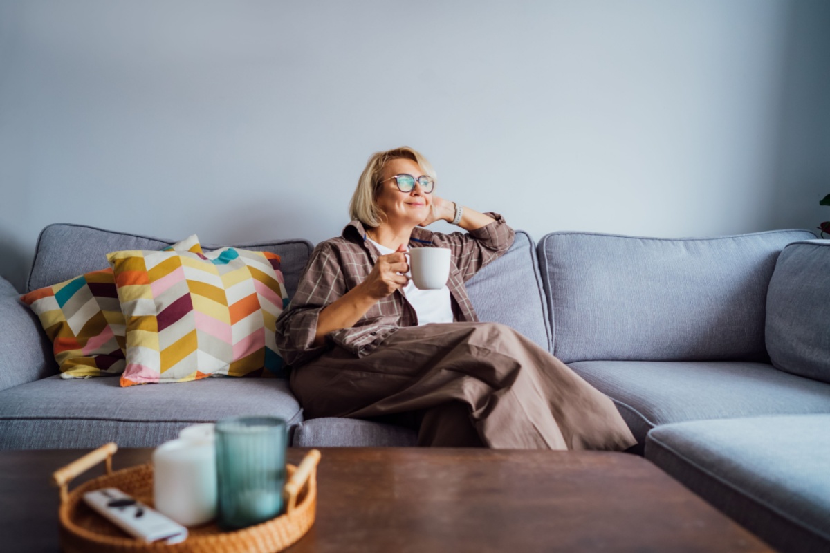 middleaged woman sitting on the couch with a cup of coffee