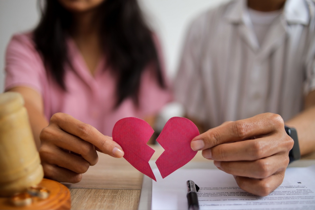 pareja sosteniendo un corazón roto de papel