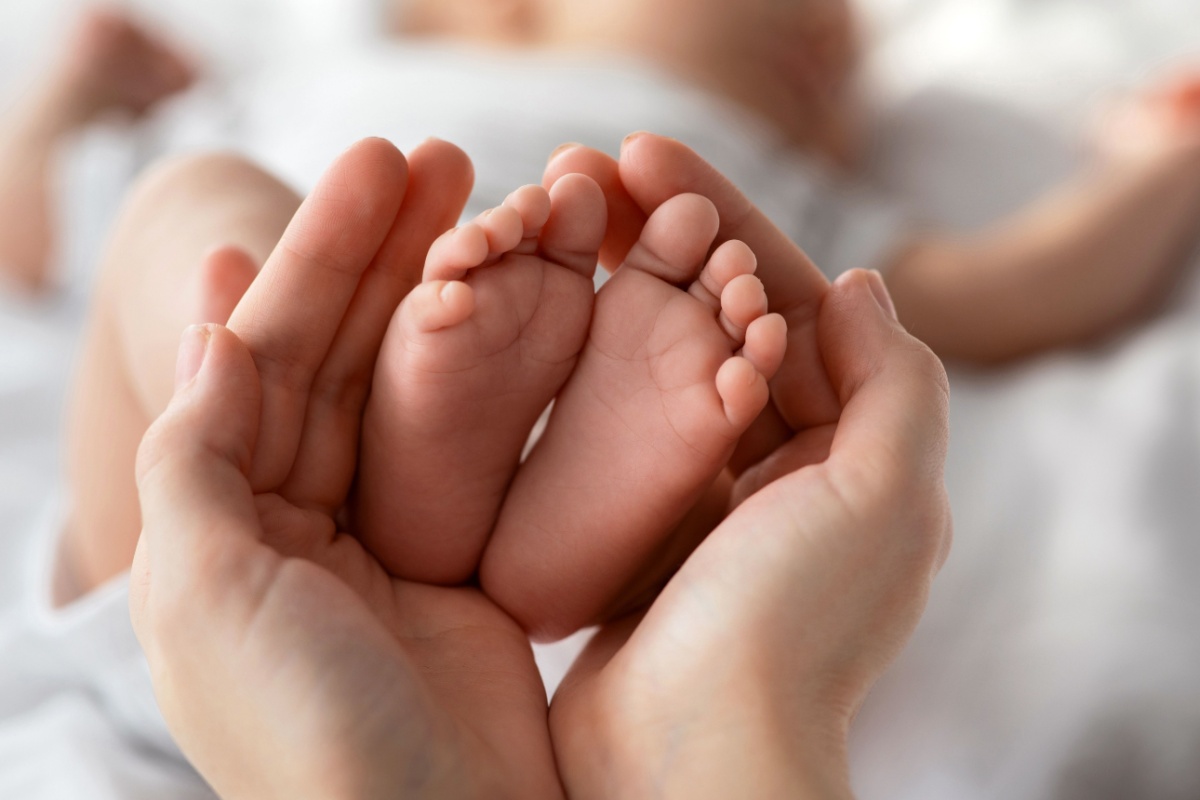 mom holding her newborn baby feet