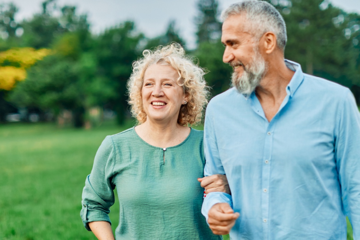 una pareja de mediana edad paseando del brazo al aire libre