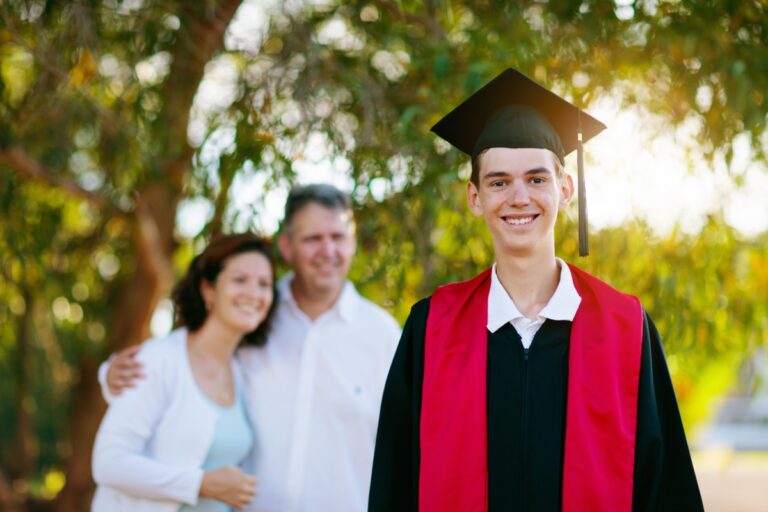 graduated teen and his parents behind him