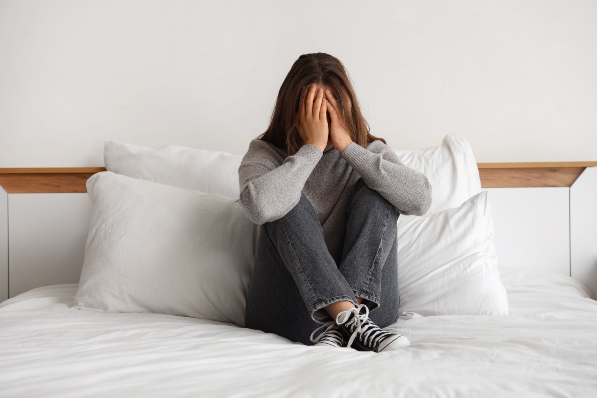 sad teen at bed