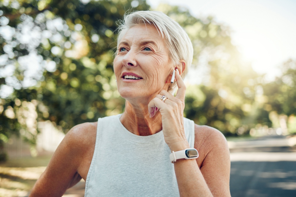 middle aged woman with headphones at the park