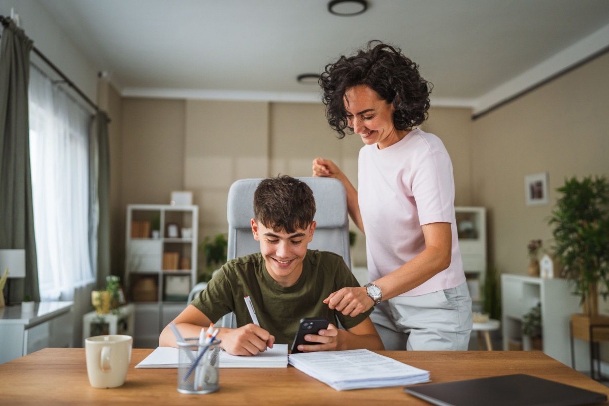 adolescente escribiendo a mano junto a su madre