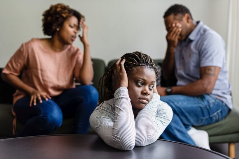 adolescente angustiada con sus padres detrás