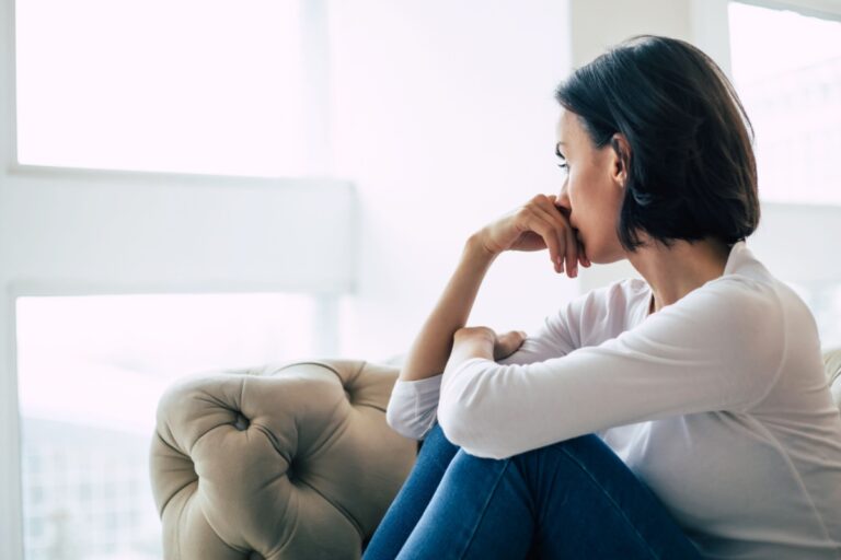mujer pensativa mirando por la ventana