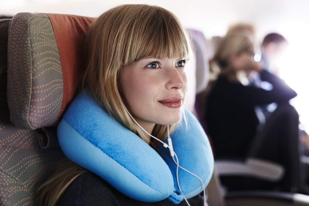 woman on a plane with a pillow