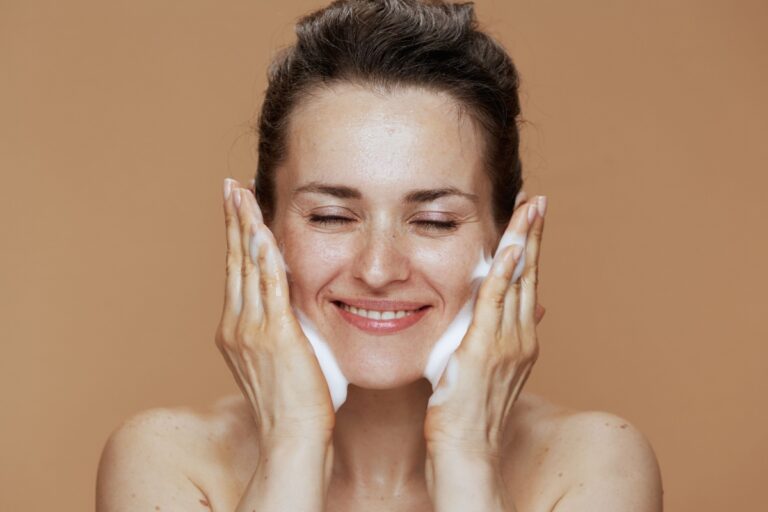 mujer exfoliandose el rostro