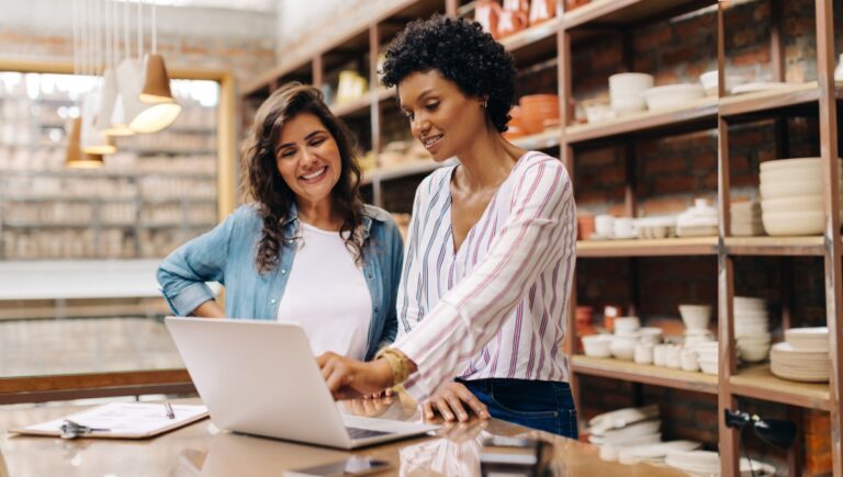 dos mujeres en un taller viendo una notebook