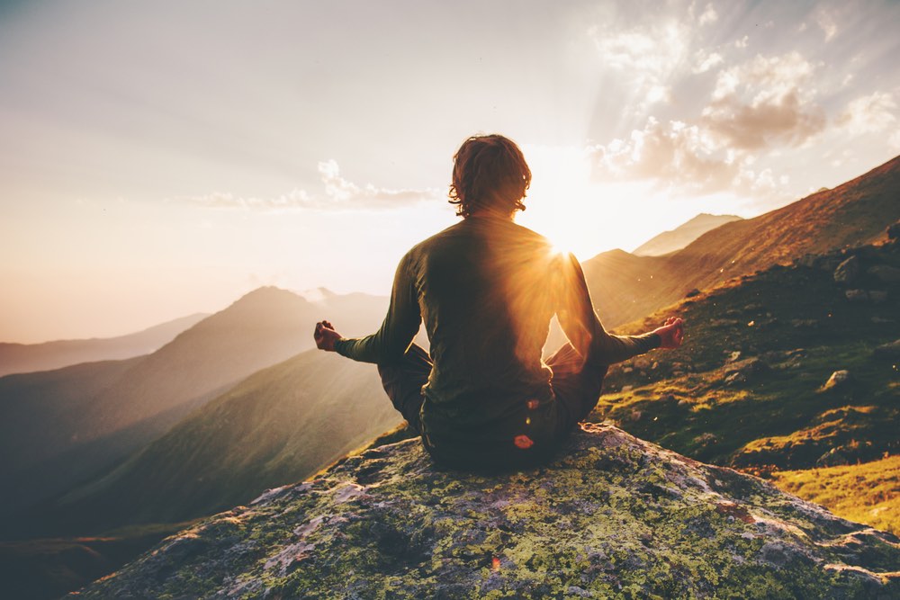 Man meditating on mountain