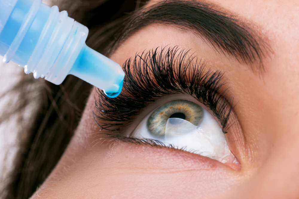 Mujer aplicando gotas en los ojos