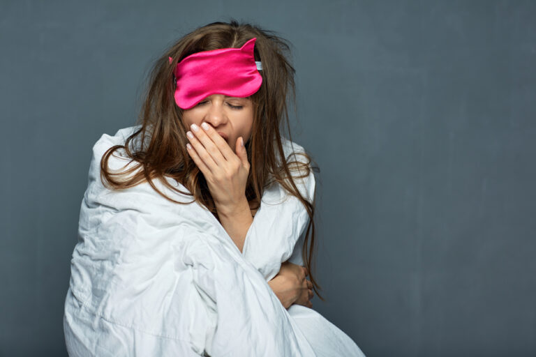 Woman with weighted blanket and eye mask