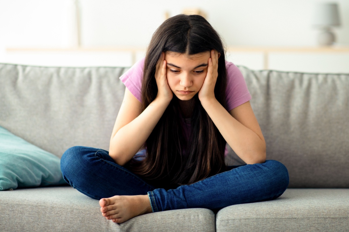 sad teenager sitting in a couch