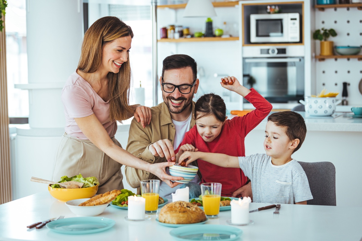 madre, padre y dos niños comiendo juntos