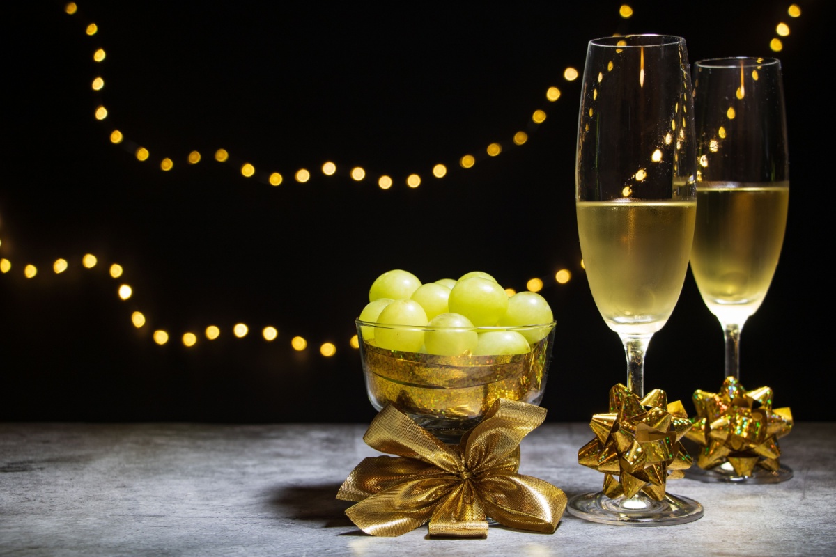 two glasses with champagne, and a bowl with grapes