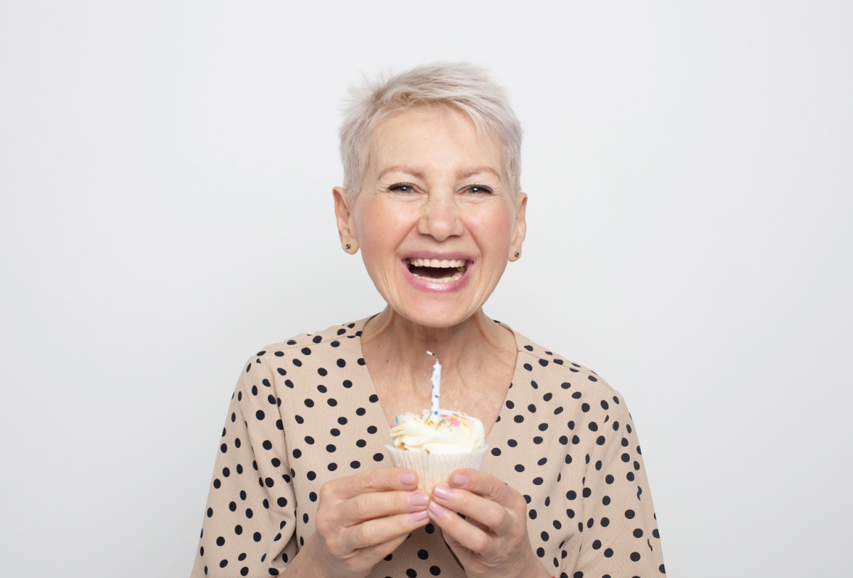 mujer sosteniendo un muffin con una vela