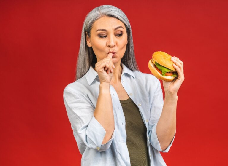Gray haired woman with a hamburger